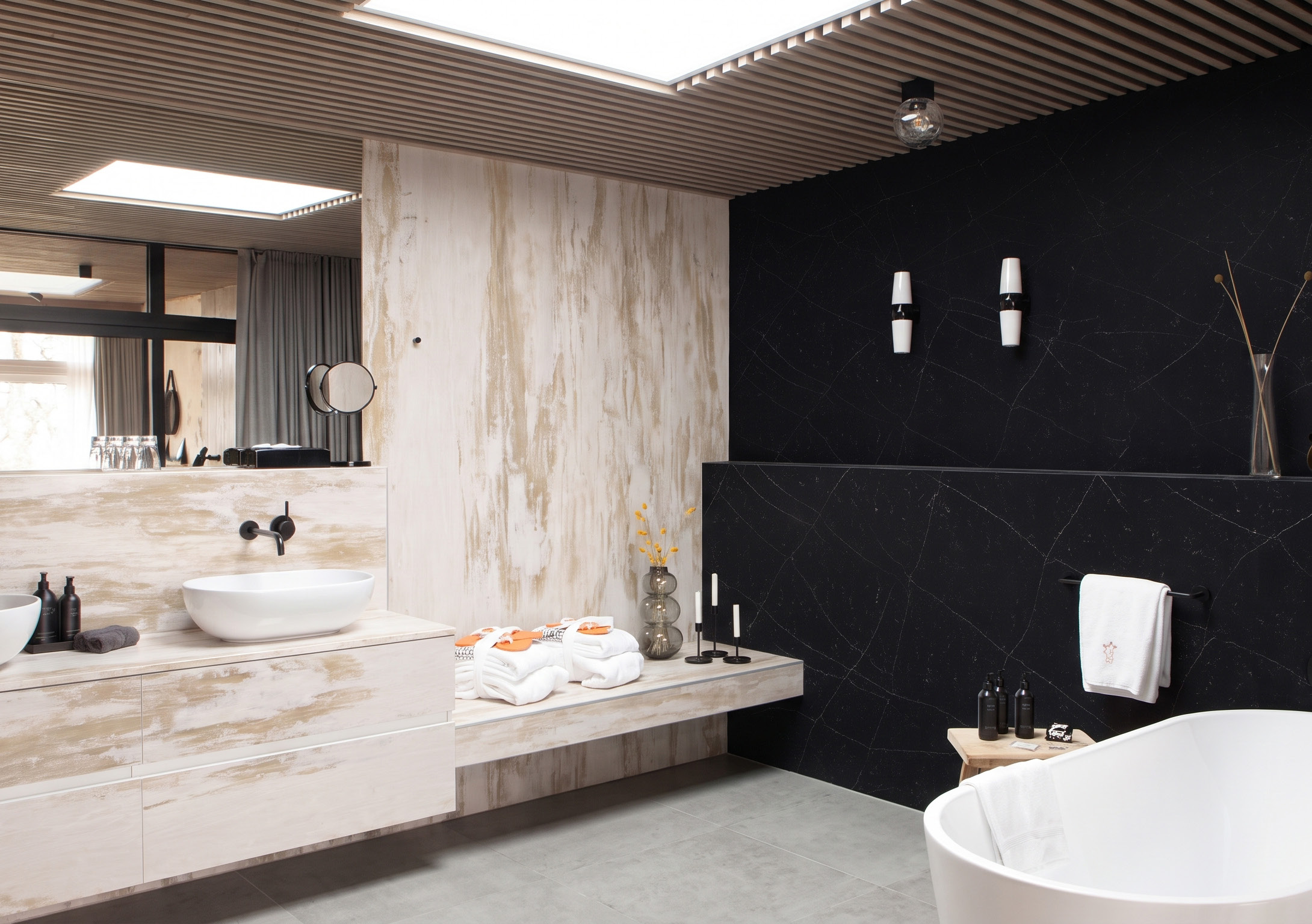 A bathroom with a stone vanity counter, a basin and a bath