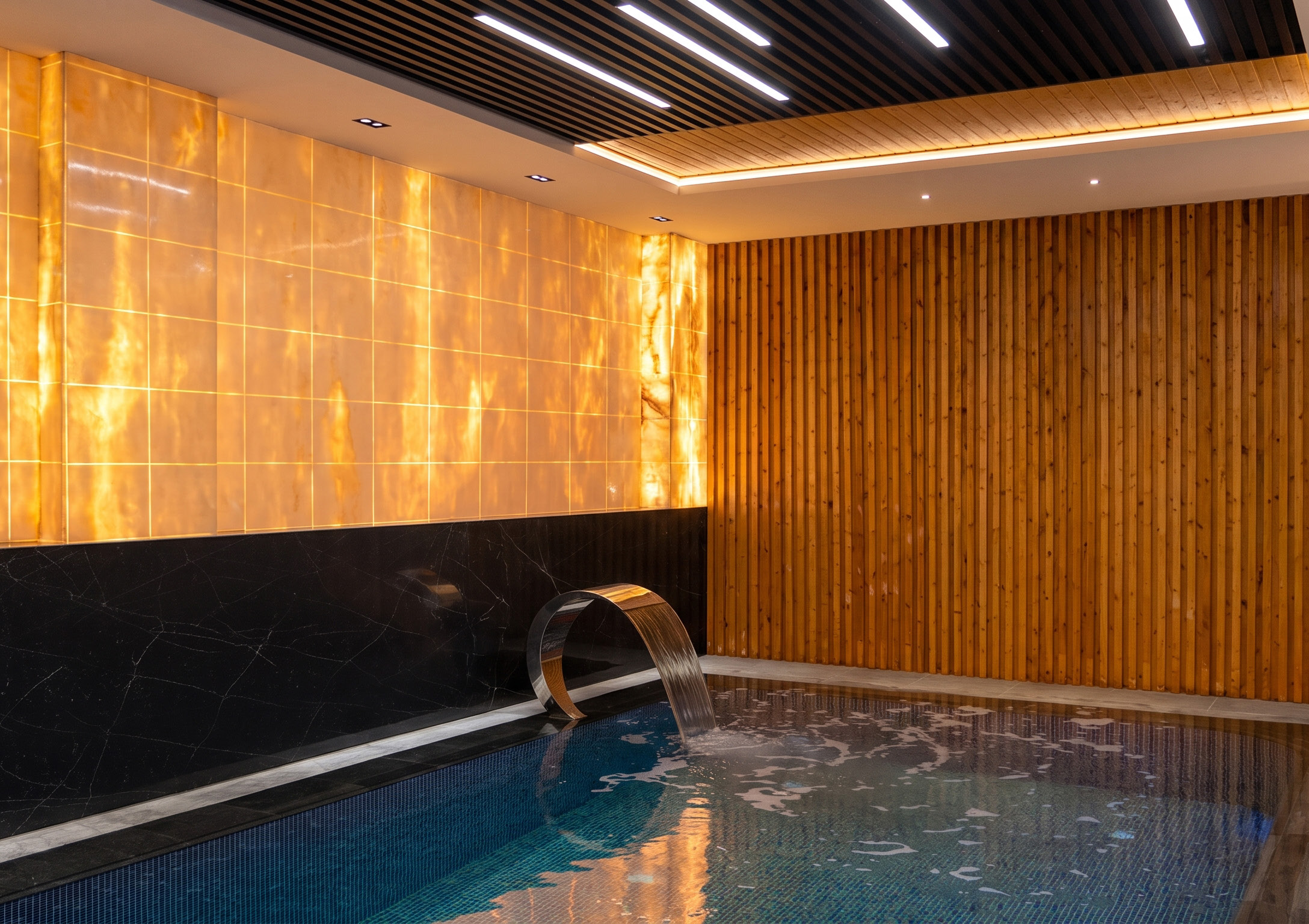 An indoor pool beside a backlit wall
