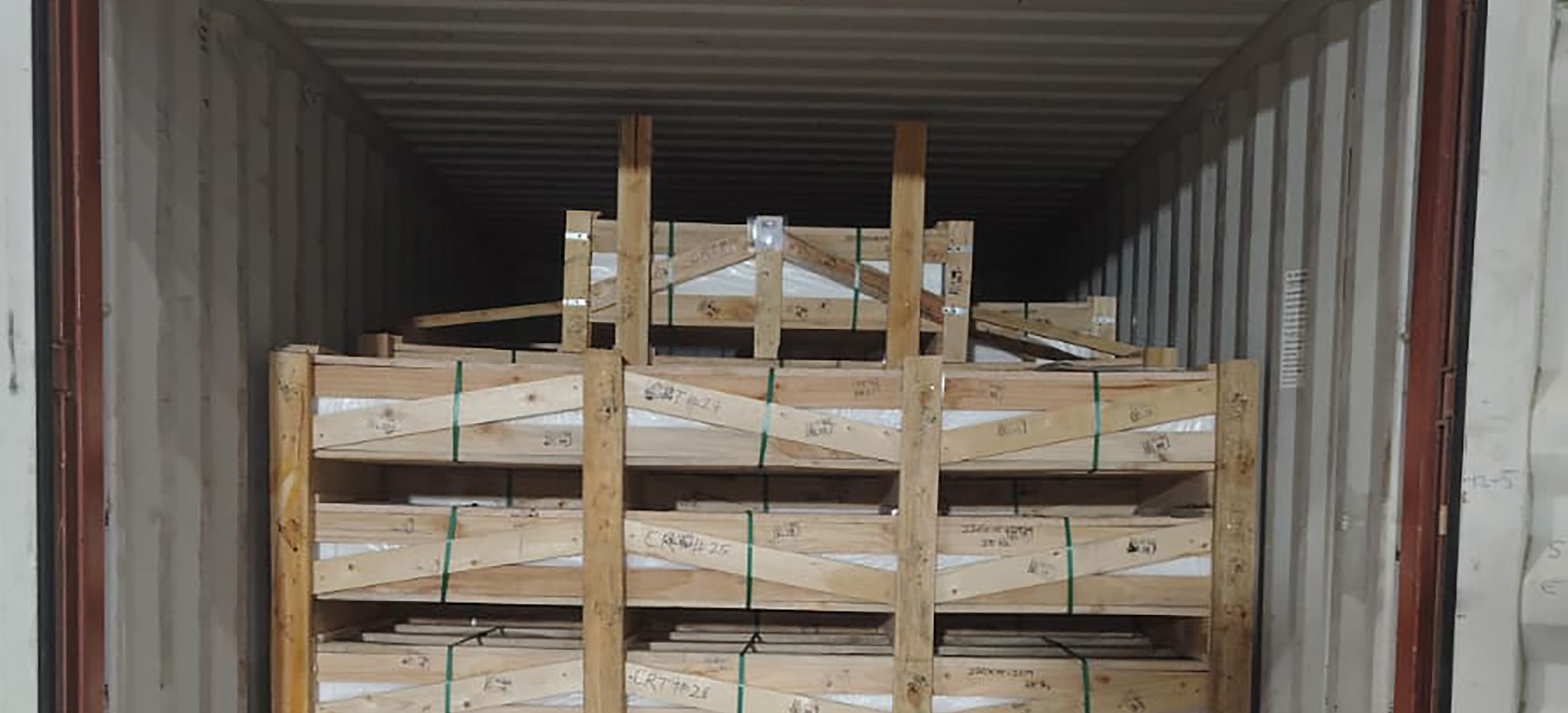 Wooden crates of sills strapped inside a shipping container