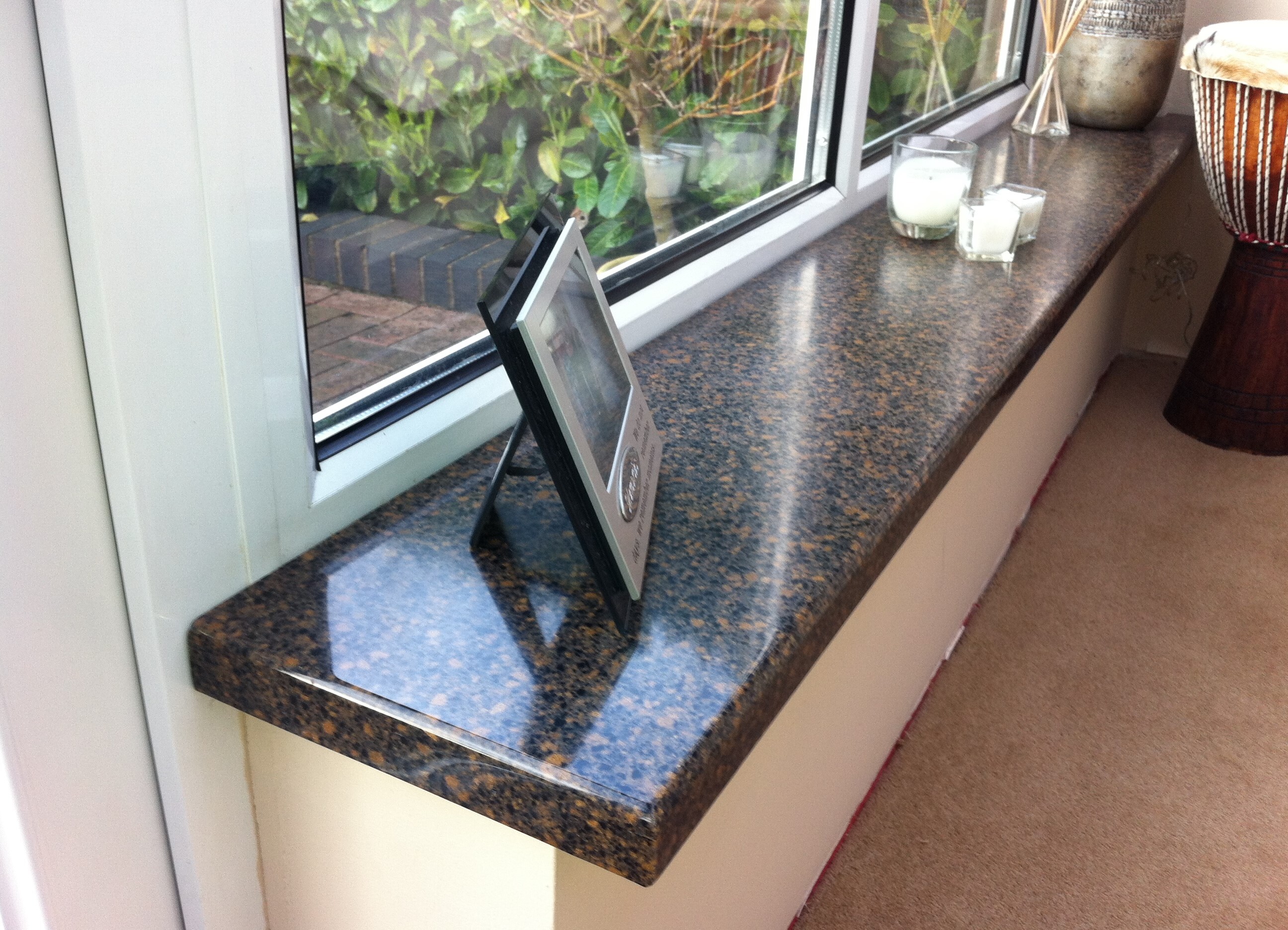 A brown granite window sill with a picture frame on it