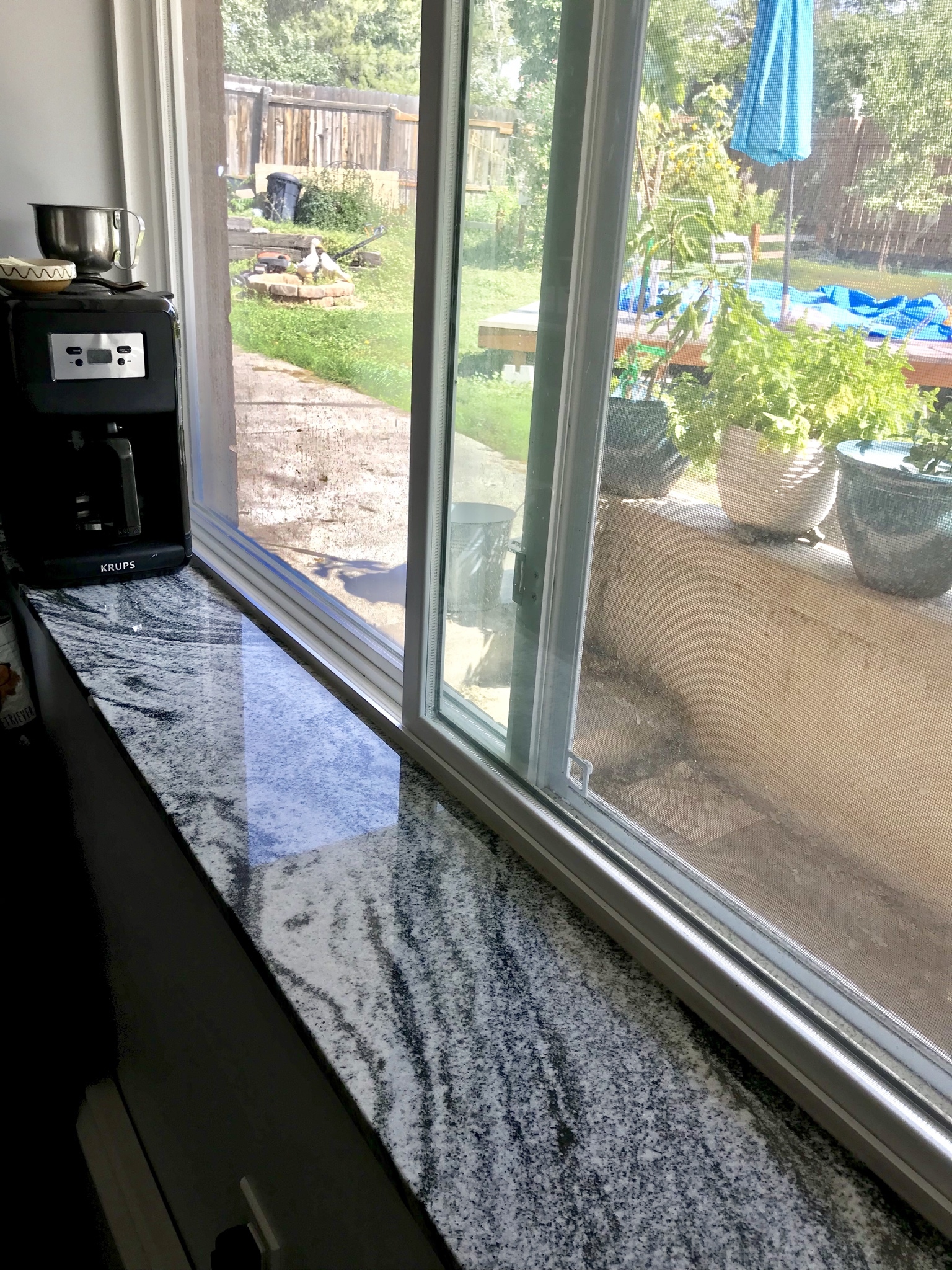 A black and white granite sill along a kitchen window