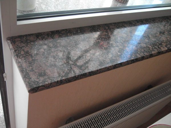 A pink and grey granite sill above a radiator